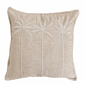 A square beige linen throw pillow featuring white embroidered palm tree designs on the front, finished with a decorative whipstitched border.